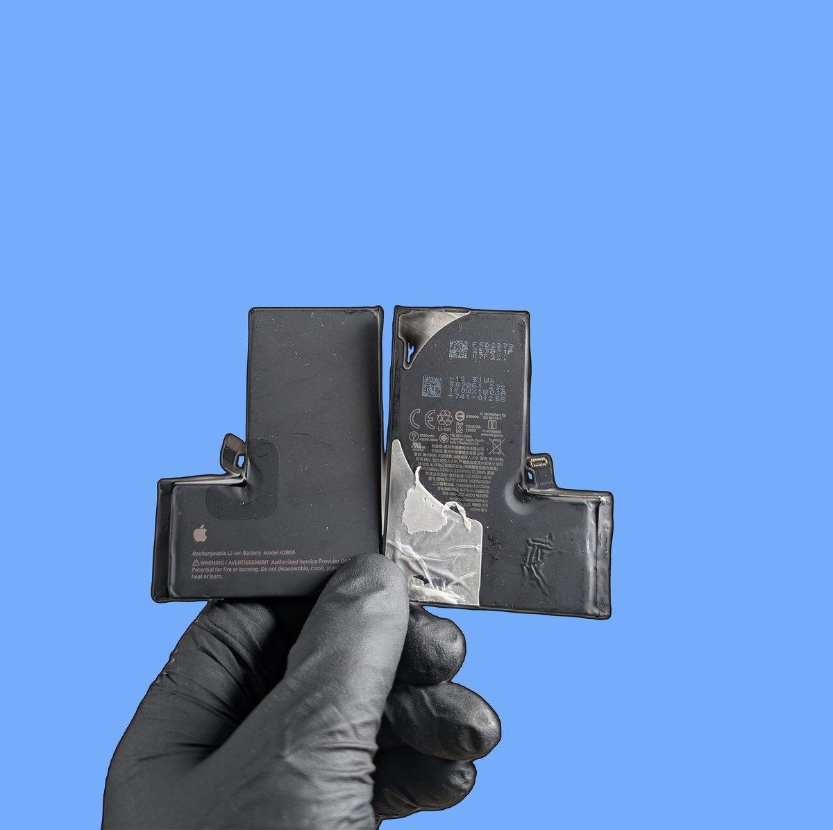 iPhone batteries held in black repair gloves